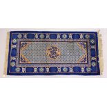 A SMALL CHINESE RUNNER RUG, central motif, blue border with motifs. 4ft 10ins x 2ft 4ins.