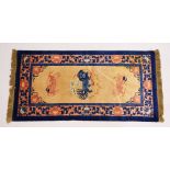A CHINESE RUG, the centre with Dog of Fo motifs, beige ground and blue border. 5ft x 2ft 5ins.``