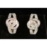 A PAIR OF 14CT WHITE GOLD DIAMOND EARRINGS in the form of knots.