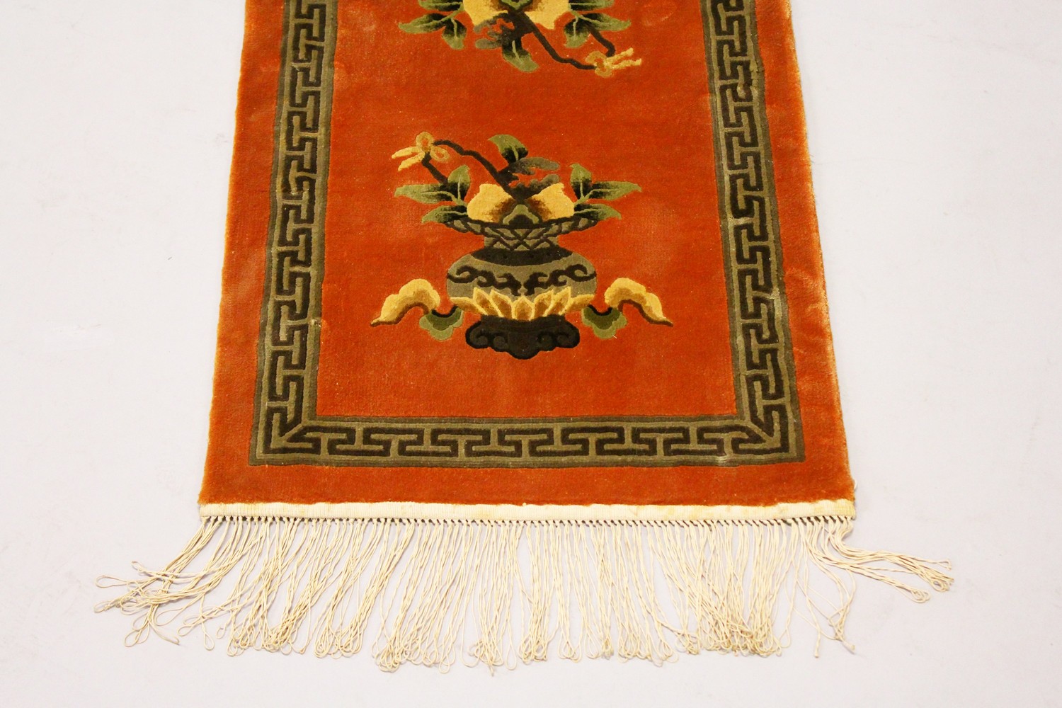 A CHINESE RUG, rust ground decorated with two urns; together with a Chinese mat. 2ft 7ins x 1ft