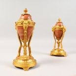 A SMALL PAIR OF MARBLE AND ORMOLU CASSOLETTES, with reversible tops, on circular bases. 8ins high.
