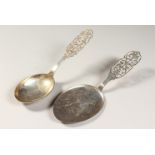 TWO SWEDISH SILVER SPOONS, with ornate pierced handles. 7ins and 7.5ins long.