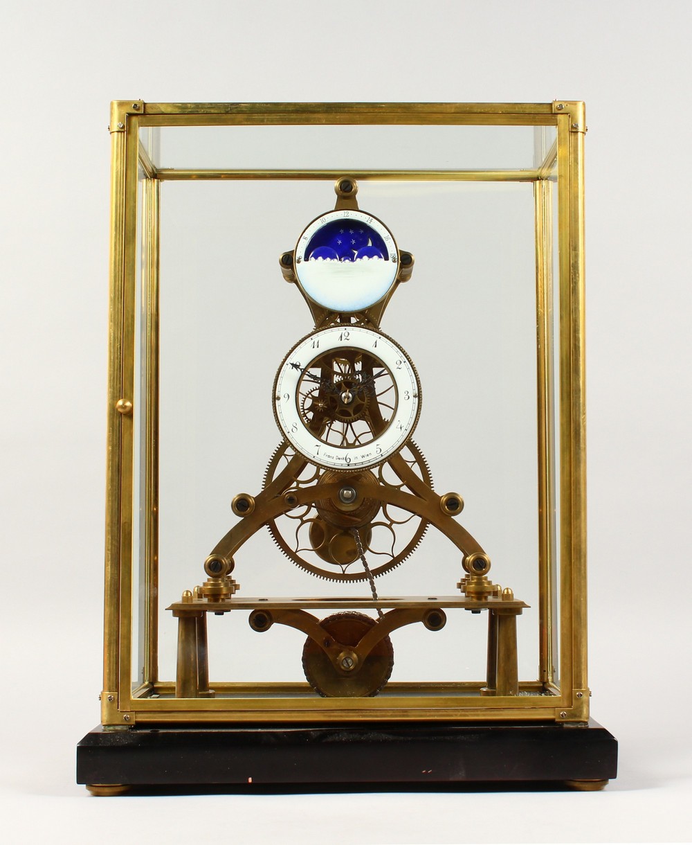 A MOON PHASE SKELETON CLOCK in a glass case. 17.5ins high including case.