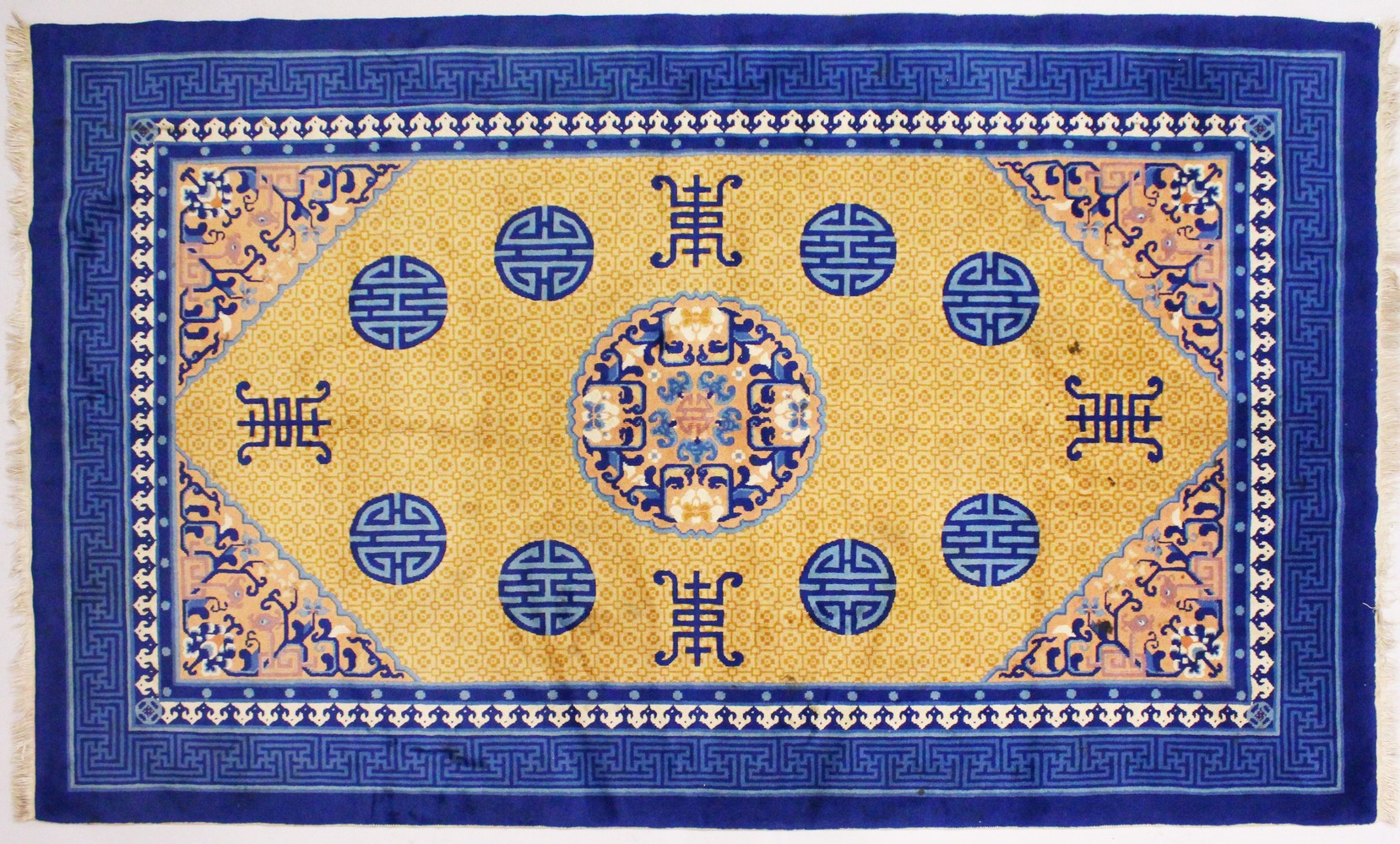 A CHINESE CARPET, with blue border and eight blue medallions. 8ft 2ins x 5ft.