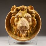 A RELIEF CAST TERRACOTTA ROUNDEL OF A LIONS HEAD, with traces of painted decoration. 12.5ins