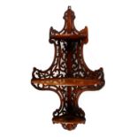 A 19TH CENTURY WALNUT CORNER WALL SHELF, with pierced decoration. 2ft 10ins high x 11ins deep.