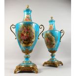 A PAIR OF BLUE SEVRES DESIGN TWO-HANDLED URN SHAPED VASES AND COVERS, light blue ground with reverse