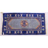 A CHINESE RUG, with blue ground, central motifs and motifs to the border. 5ft x 2ft 4ins.