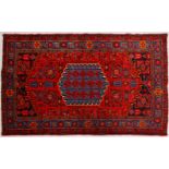 A PERSIAN RUG, mainly red ground, with central motif and triple row border. 6ft 6ins x 4ft 6ins.