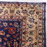 A VERY GOOD LARGE PERSIAN CARPET, mainly blue ground, floral motifs, within a deep border. 14ft x