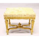 A 19TH CENTURY CARVED GILT FRAMED STOOL, overstuffed seat on turned, carved tapering legs, united by