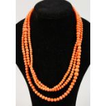 A LONG CORAL SINGLE STONE NECKLACE.