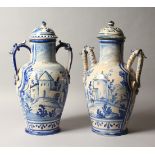 A LARGE PAIR OF DELFT BLUE AND WHITE TWO-HANDLED POTTERY VASES AND COVERS painted with a town scene.