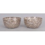 A PAIR OF CHINESE SILVER DRAGON BOWLS, circa 1900, weighing approx. 300gm, the sides of each pierced