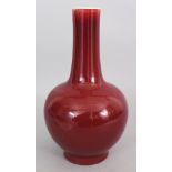 AN EARLY 20TH CENTURY CHINESE SANG-DE-BOEUF PORCELAIN BOTTLE VASE, 7.25in wide at widest point &