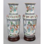 A PAIR OF 19TH CENTURY CHINESE FAMILLE VERTE PORCELAIN VASES, together with fixed wood stands, 10.