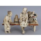 A GOOD QUALITY SIGNED JAPANESE MEIJI PERIOD SECTIONAL IVORY OKIMONO OF A BASKET & DRUM SELLER &