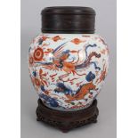 A CHINESE IMARI KANGXI PERIOD PORCELAIN JAR, circa 1700, together with a wood stand and cover, the