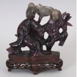 AN EARLY 20TH CENTURY AMETHYST FLUORITE CARVING OF GUANYIN & A BOY ATTENDANT, both bearing lotus,