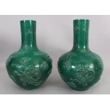 A LARGE PAIR OF CHINESE GREEN GLAZED PORCELAIN DRAGON BOTTLE VASES, each decorated in high relief
