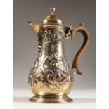 A SMALL GEORGIAN STYLE PEAR SHAPED COFFEE POT with repousse decoration and wooden handle. 6ins high.