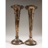 A PAIR OF FLOWER TRUMPET VASES on loaded bases. 7ins high. Birmingham 1905.