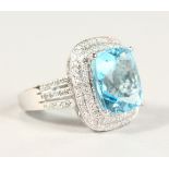 A GOOD 14K WHITE GOLD, TOPAZ AND DIAMOND CLUSTER RING, with cushion blue topaz of 8.57CTS.