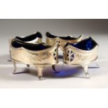 A SET OF FOUR BRIGHT CUT AND PIERCED OVAL SALTS, with blue liners, on four curving legs. London 1788