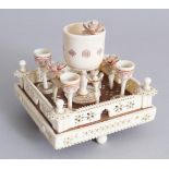 AN INDIAN CARVED IVORY AND WOODEN SQUARE MINIATURE EGG CUP STAND. 3.5ins.