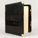 A GUCCI BLACK EMBOSSED LEATHER CASED WRITING PAD. 10ins x 9ins.