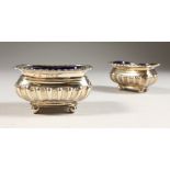 A PAIR OF VICTORIAN SEMI-FLUTED RECTANGULAR SALTS, with blue liners, on four ball feet. Chester