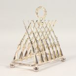 A PLATED SIX DIVISION TOAST RACK, with cross guns, on four ball feet. 8ins long.