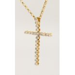 AN 18CT GOLD DIAMOND SET CROSS, on a chain.