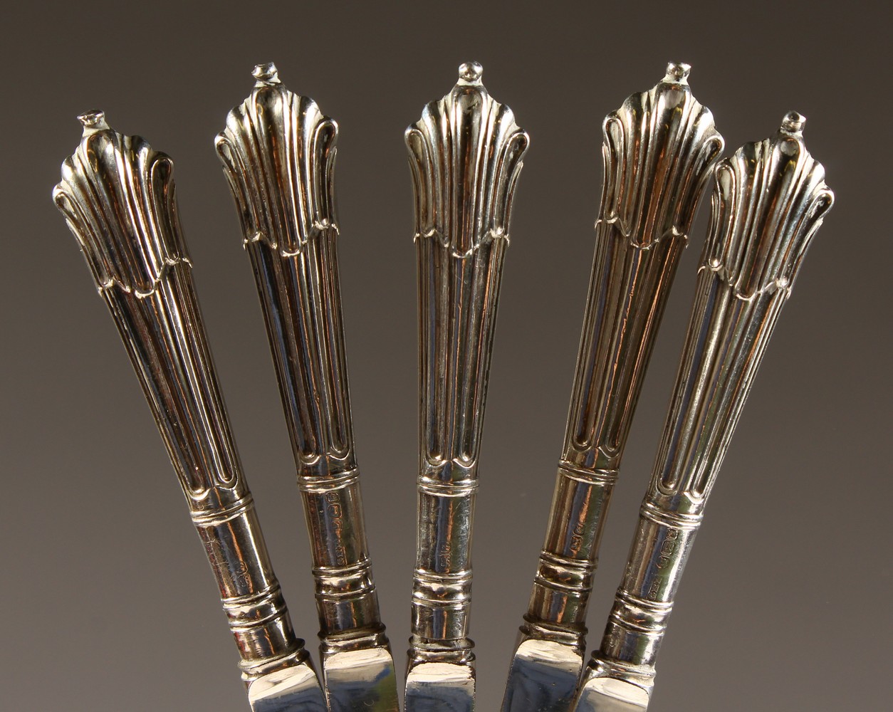 A SET OF FIVE SILVER HANDLED DESSERT KNIVES.