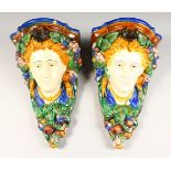 A PAIR OF MAJOLICA HEAD WALL BRACKETS. 11ins long.