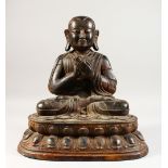 A BRONZE SEATED BUDDHA, QING DYNASTY, seated on a double lotus throne and wearing a voluminous robe,