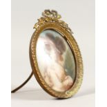 AN OVAL MINIATURE OF A LADY, wearing a plumed hat. 3ins x 2.5ins, in a gilt metal frame.