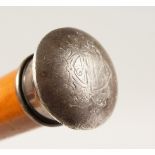 A WALKING CANE, with silver handle. 33ins long.