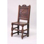 A 17TH CENTURY OAK CHAIR, with carved cresting and panel back, plain seat, turned front supports