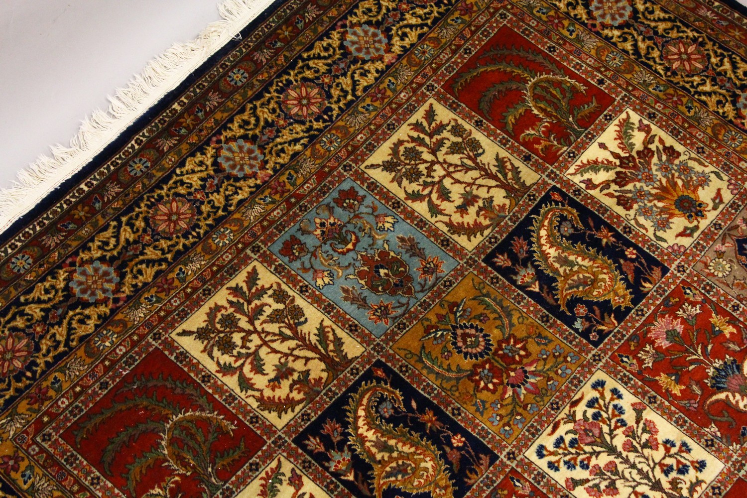 A VERY GOOD LARGE PERSIAN "GHOM" CARPET, the centre with seven rows of four floral motifs, varying