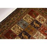 A VERY GOOD LARGE PERSIAN "GHOM" CARPET, the centre with seven rows of four floral motifs, varying