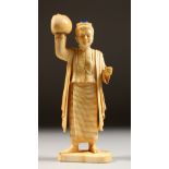 AN IVORY FIGURE OF A MAN holding a ball. 6ins high.