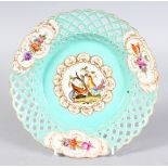 A circular dish with pierced border, the central panel painted with roosters and gilt decoration.