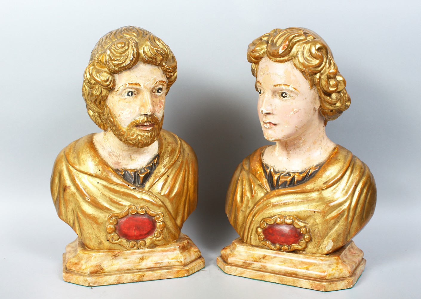 A GOOD PAIR OF 18TH CENTURY ITALIAN CARVED WOOD, PAINTED AND GILDED BUSTS. 16ins high.