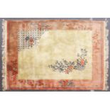 A LARGE CHINESE CARPET, beige ground with floral decoration, with a similar peach ground border.