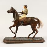 A PAINTED METAL FIGURE OF A JOCKEY ON A HORSE, with painted decoration. 7.5ins high.