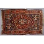 A PERSIAN CARPET, blue and red ground, decorated with stylised motifs. 8ft 3ins x 5ft 3ins.
