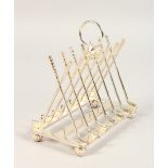 A PLATED SIX DIVISION TOAST RACK, with cross clubs, ball on four ball feet. 6ins long.