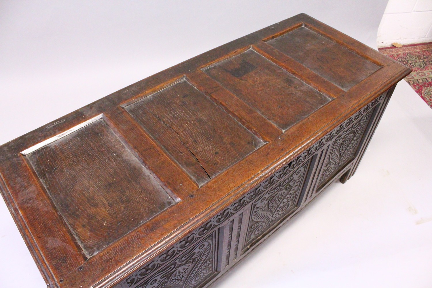 A 17TH CENTURY OAK COFFER, with a four panelled top, over a carved frieze and three carved panels, - Image 4 of 7