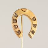 A 9CT GOLD HORSESHOE TIE PIN, set with diamonds.